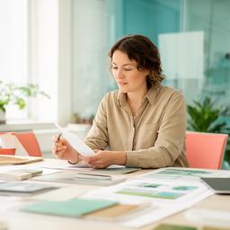 Morgan reviewing site notes in a bright meeting room with sample materials